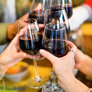 Unrecognizable friends clinking wineglasses in cafe